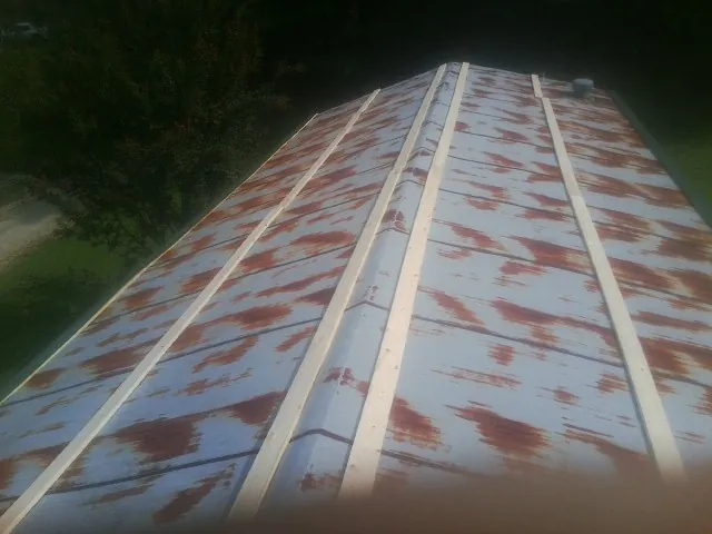 Rusted metal roof panels with new wood purlins before replacement — Storm Damage Roof Repair in Apple Valley by Roofing Brothers